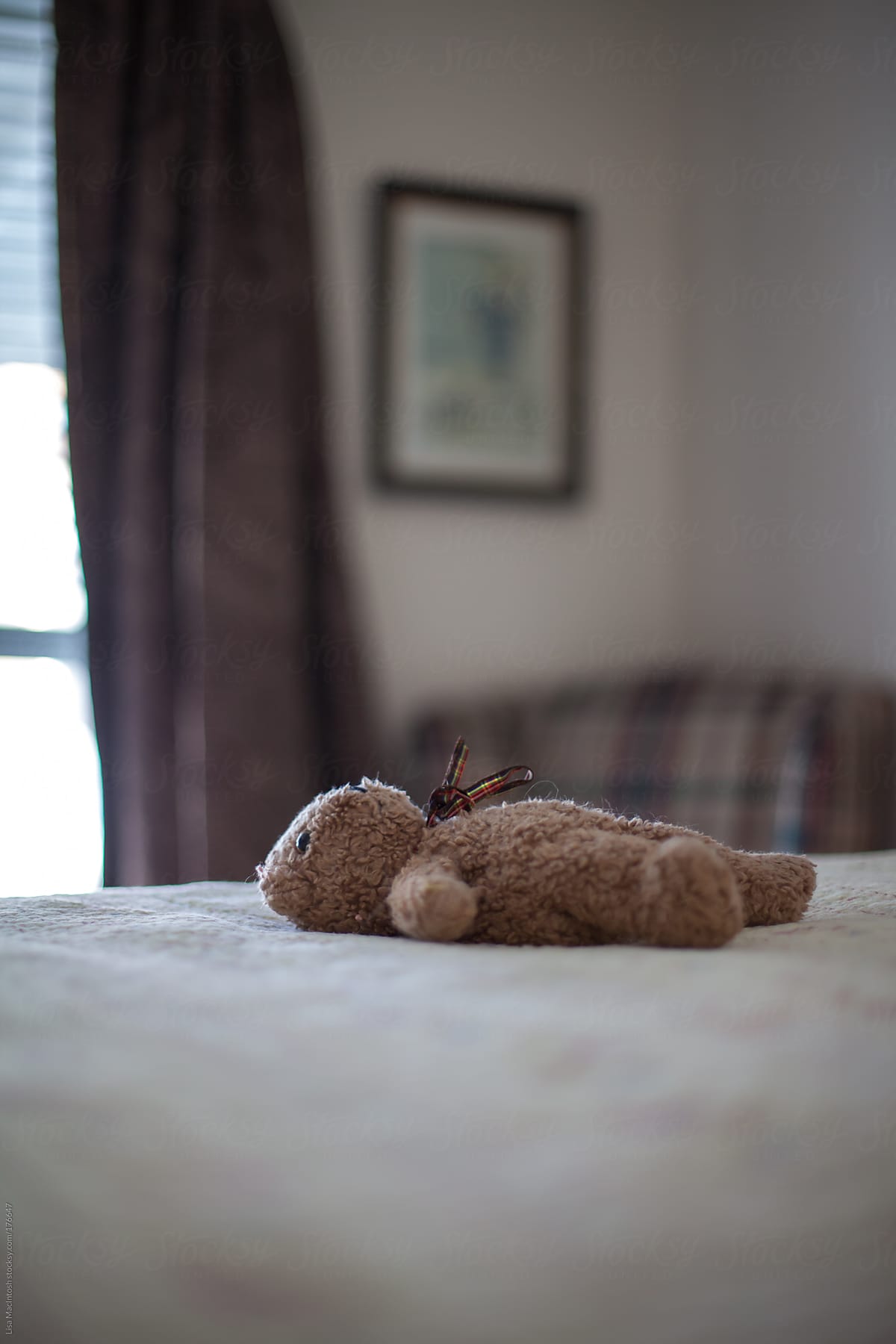 child's vintage teddy bear lying on on bed