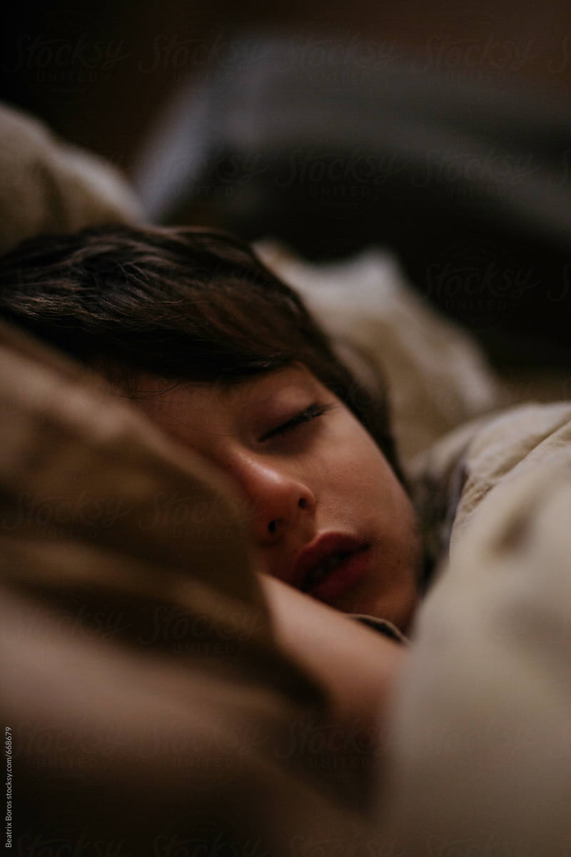 Headshot of 6 years old boy sleeping in bed