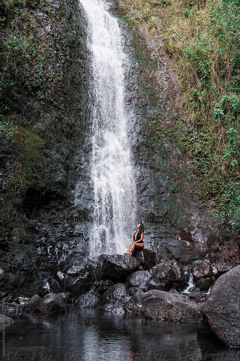 woman under Hawaiian waterfall