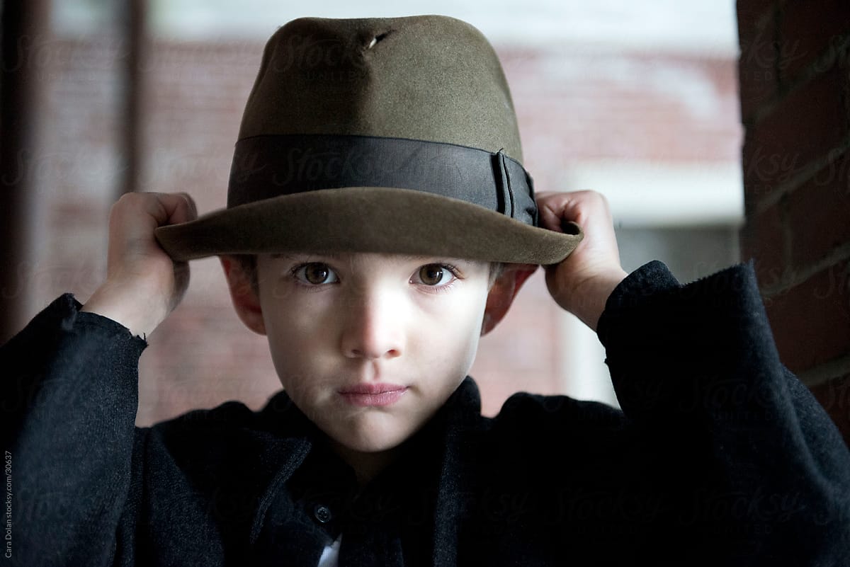 Boy adjusts his hat