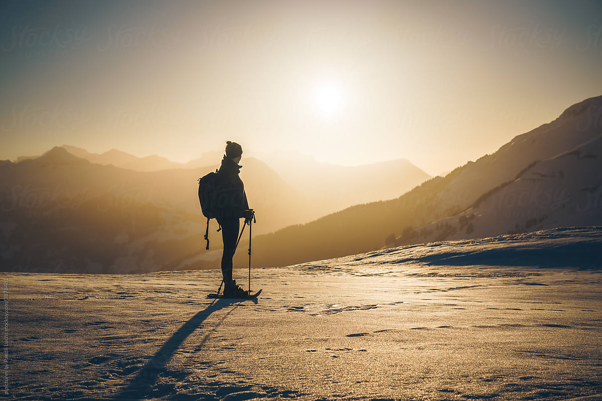 Woman enjoying the sunset view after winter hike.