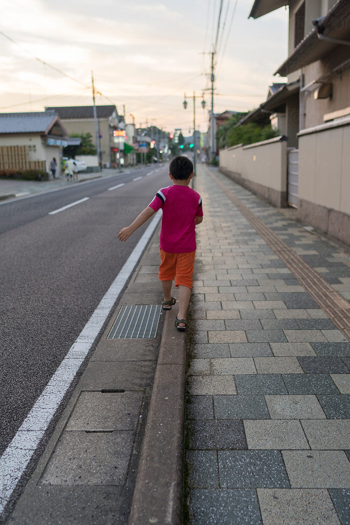 Boy walking in balance on road