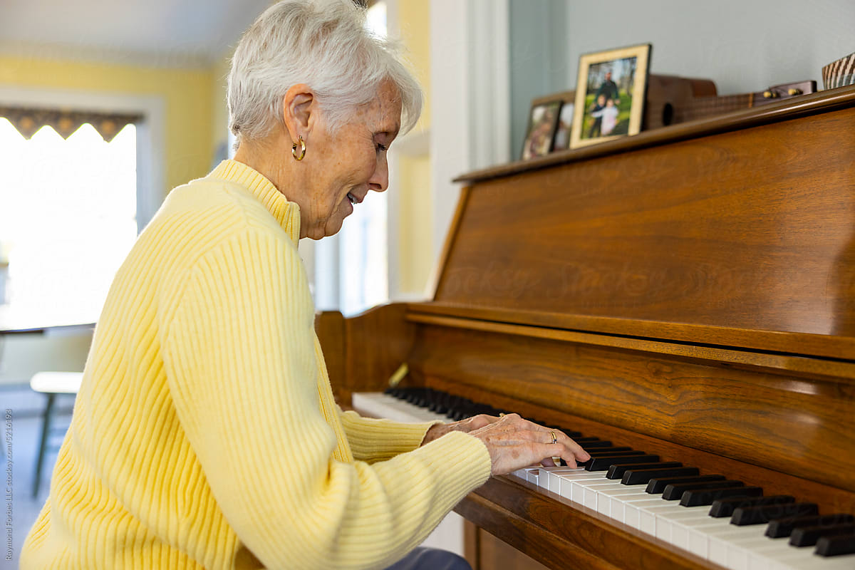 Happy Senior Citizen woman at Home playing piano Portrait