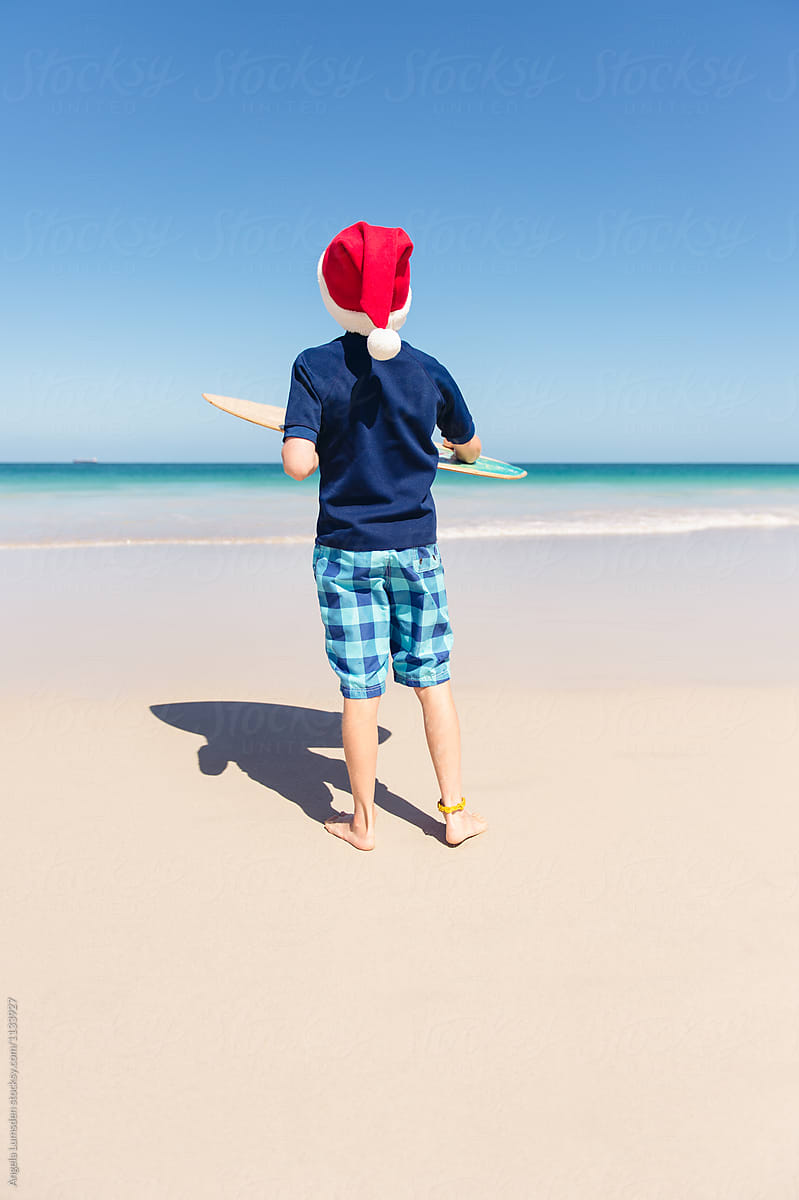 Boy at the beach with a skim board on Christmas morning