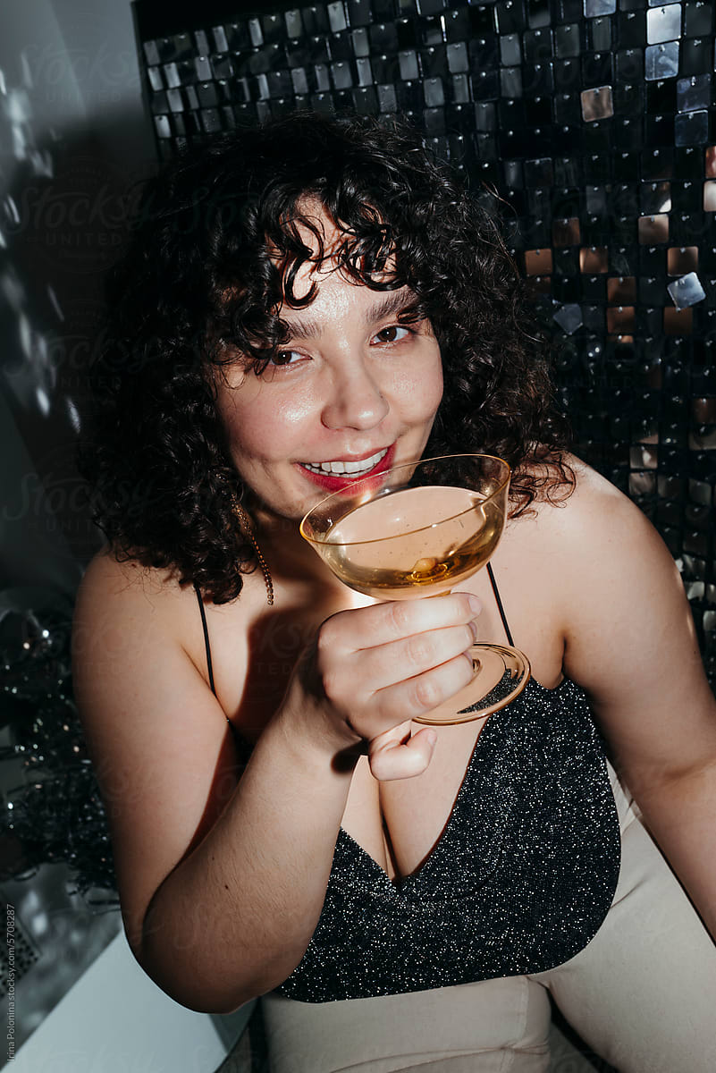 Female with glass of drink at party.