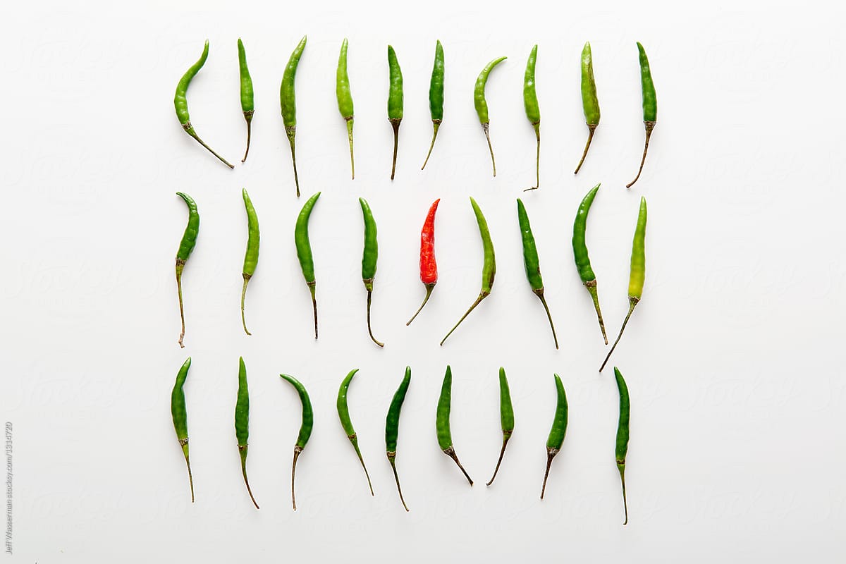 Arrangement of Green and One Red Chilli Peppers