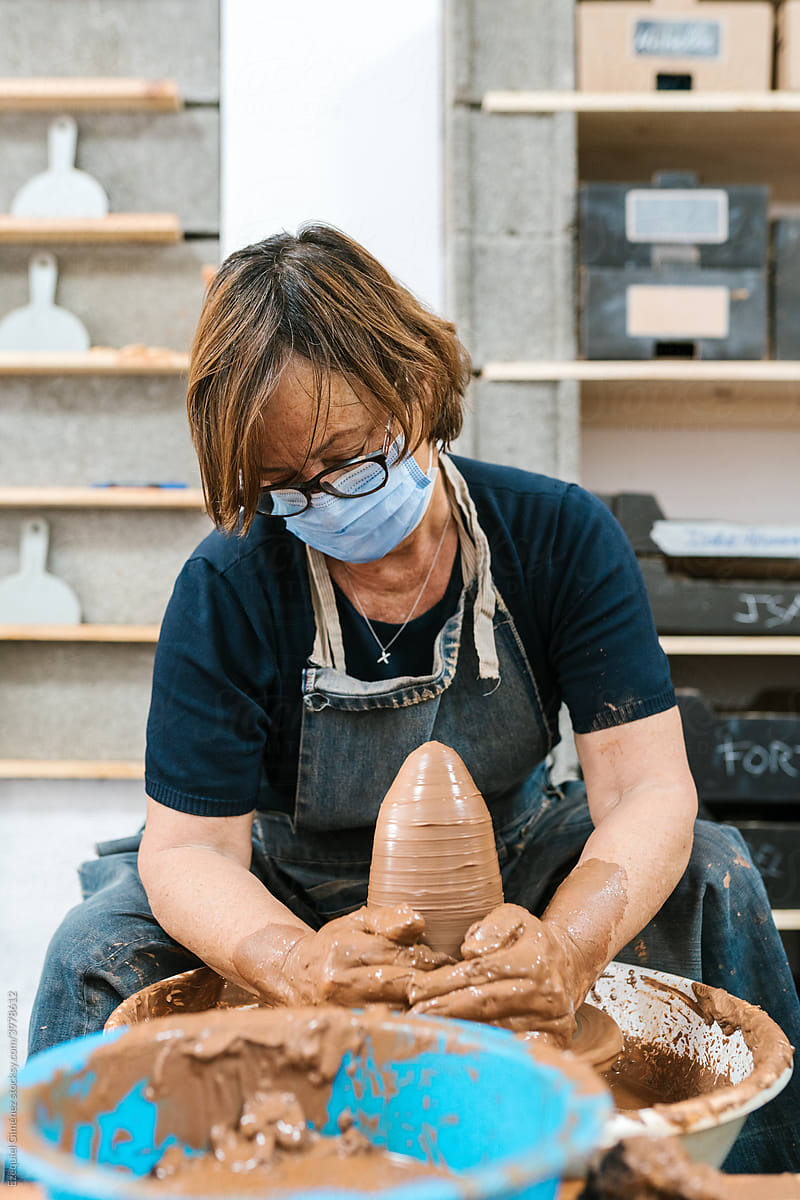 Middle-aged craftswoman working with clay