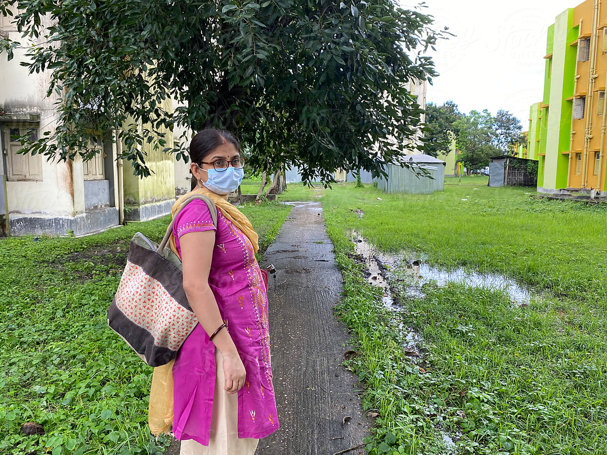 Indian woman wearing mask and stand in a locality
