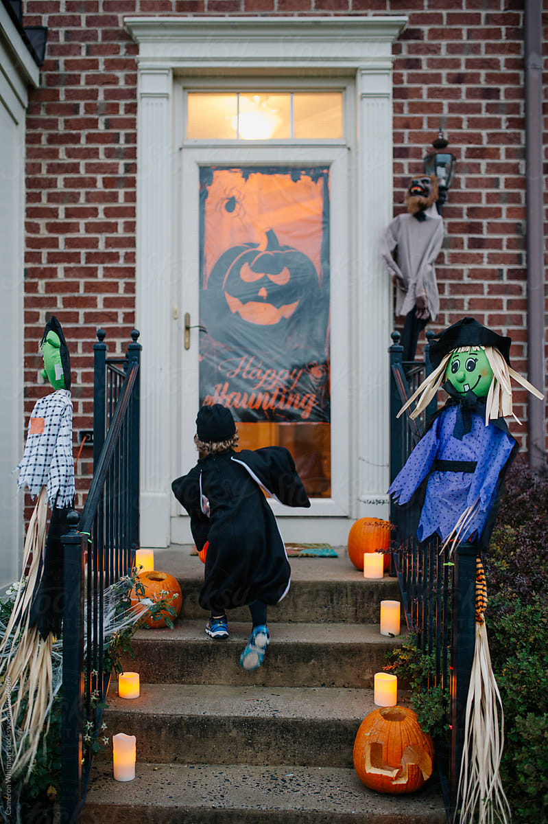 Trick or treater races up the steps to a neighbors door