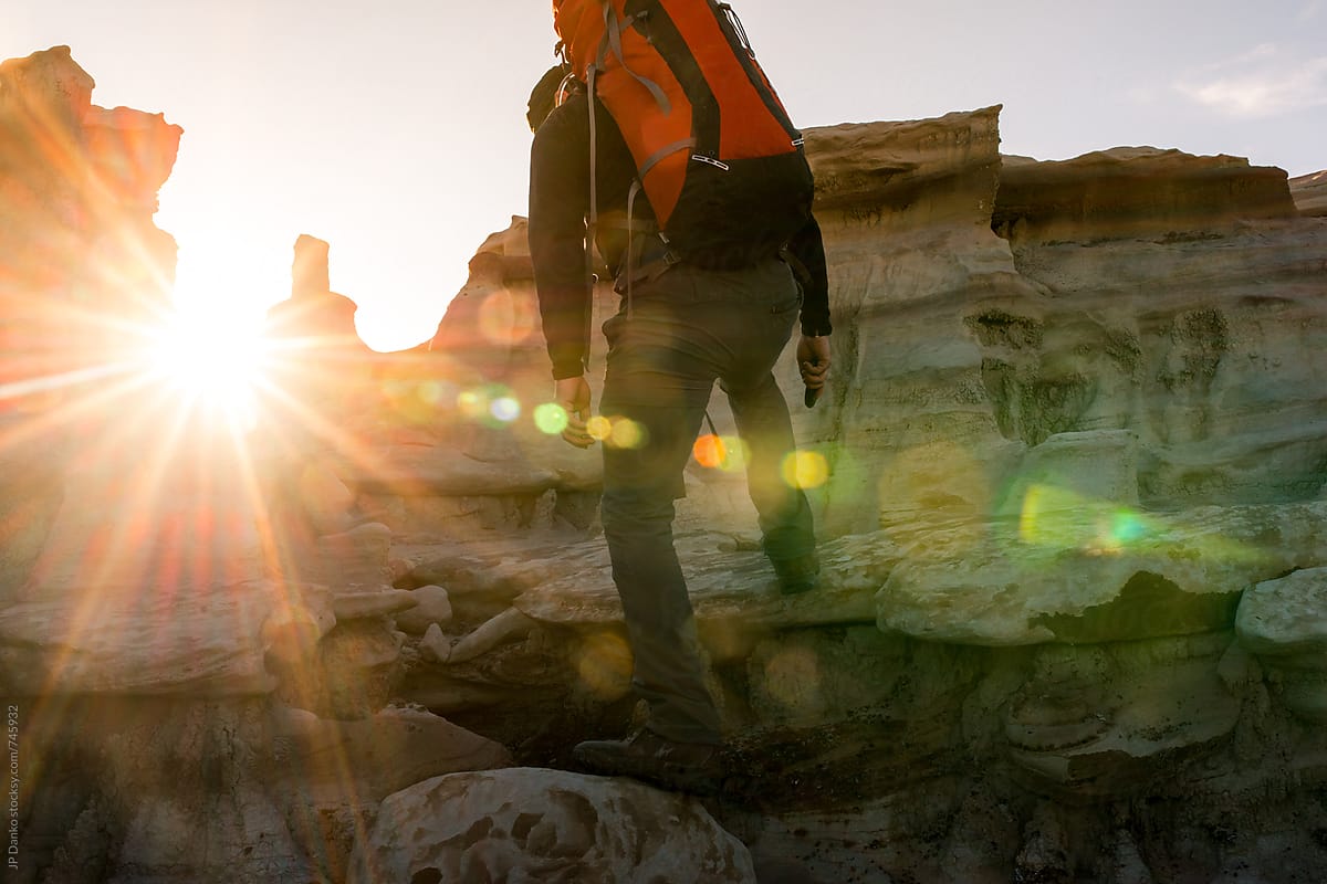 Backpacker Climbing Over Hoodoos in Bisti Badlands Wilderness Area New Mexico at Sunrise