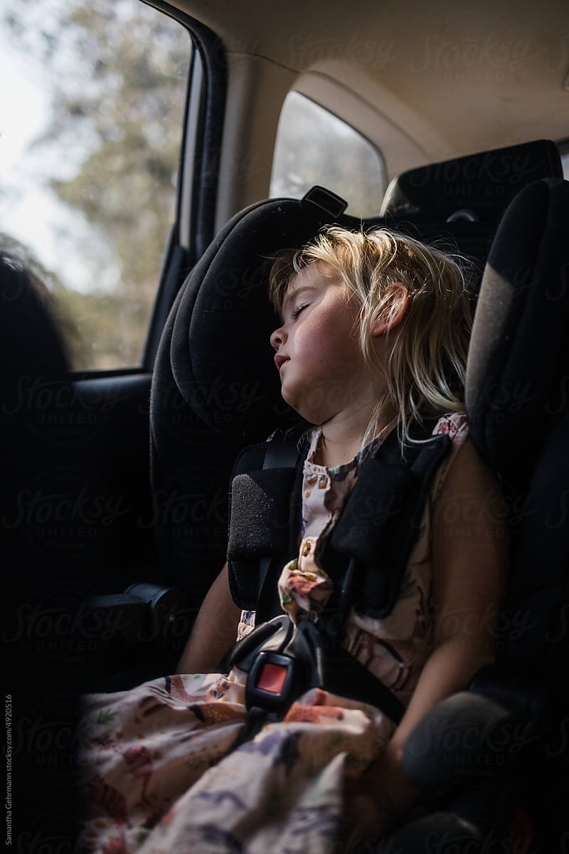 young girl asleep in car seat