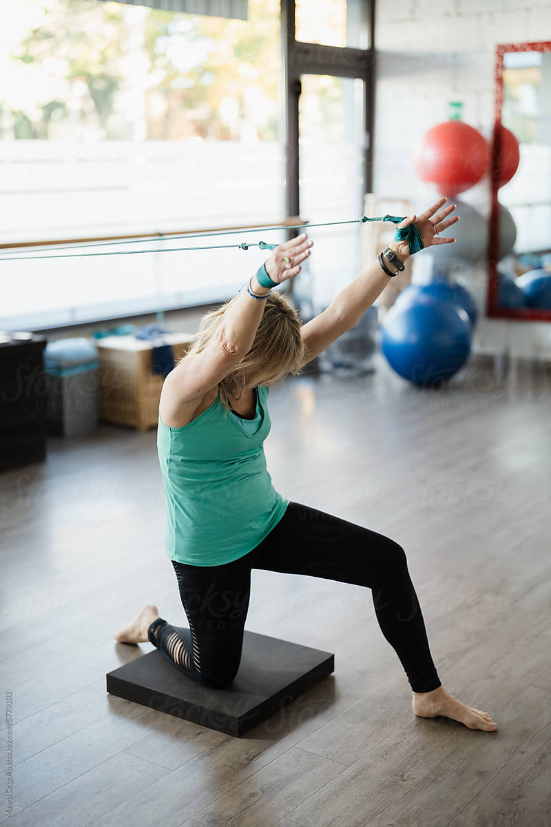 Mature woman doing pilates exercises in a gym