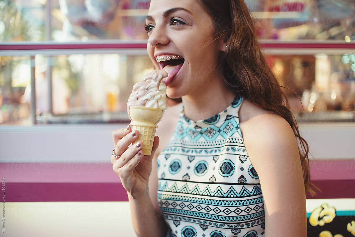 A Teenage Girl Eating Ice Cream At A Carnival By Chelsea Victoria