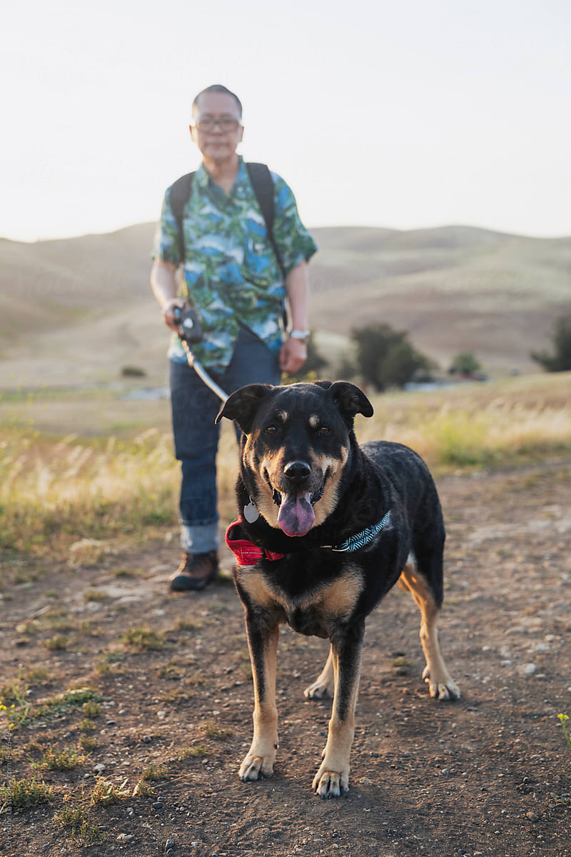 Older man hikes with his mixed-breed dog