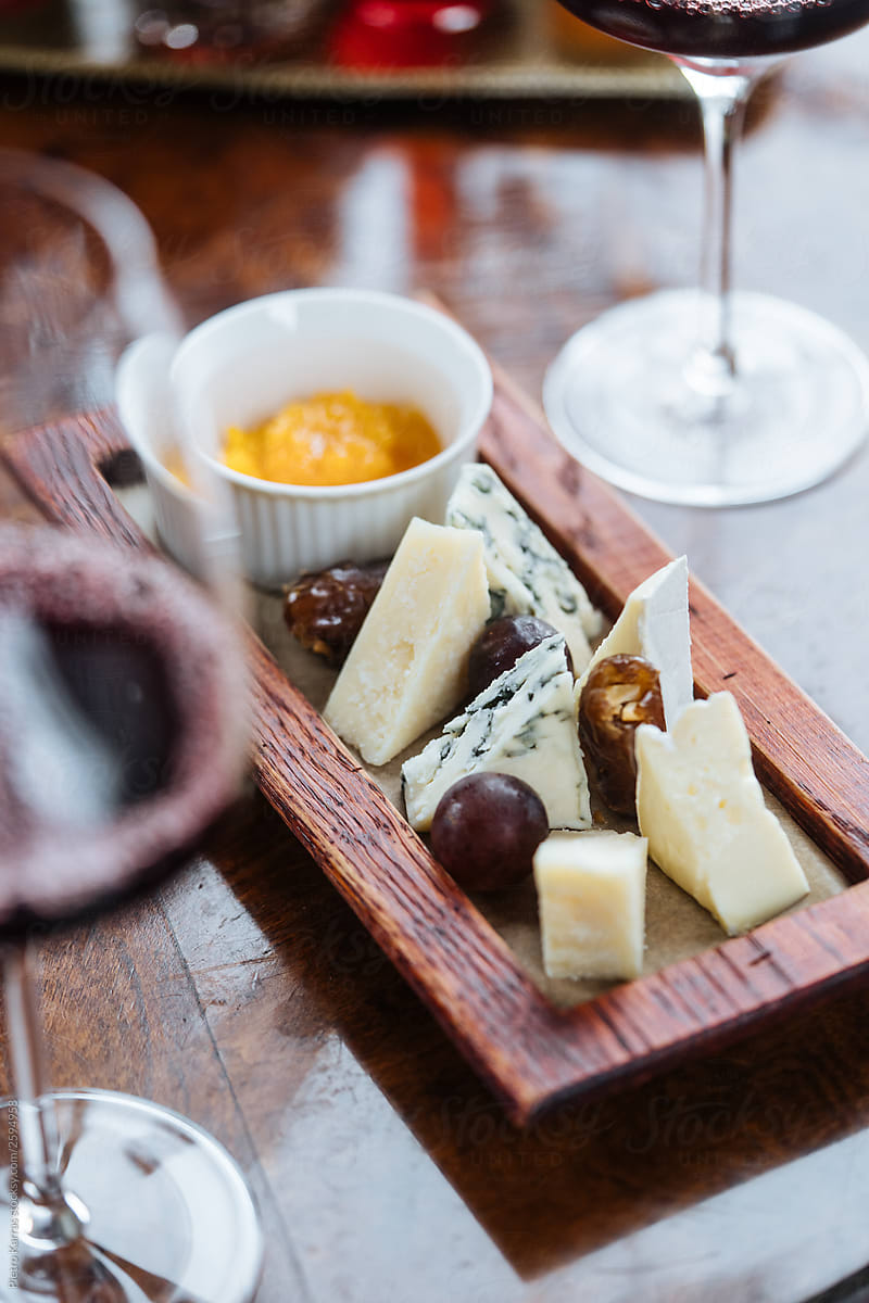 Cheese appetizer on wooden plate on served table
