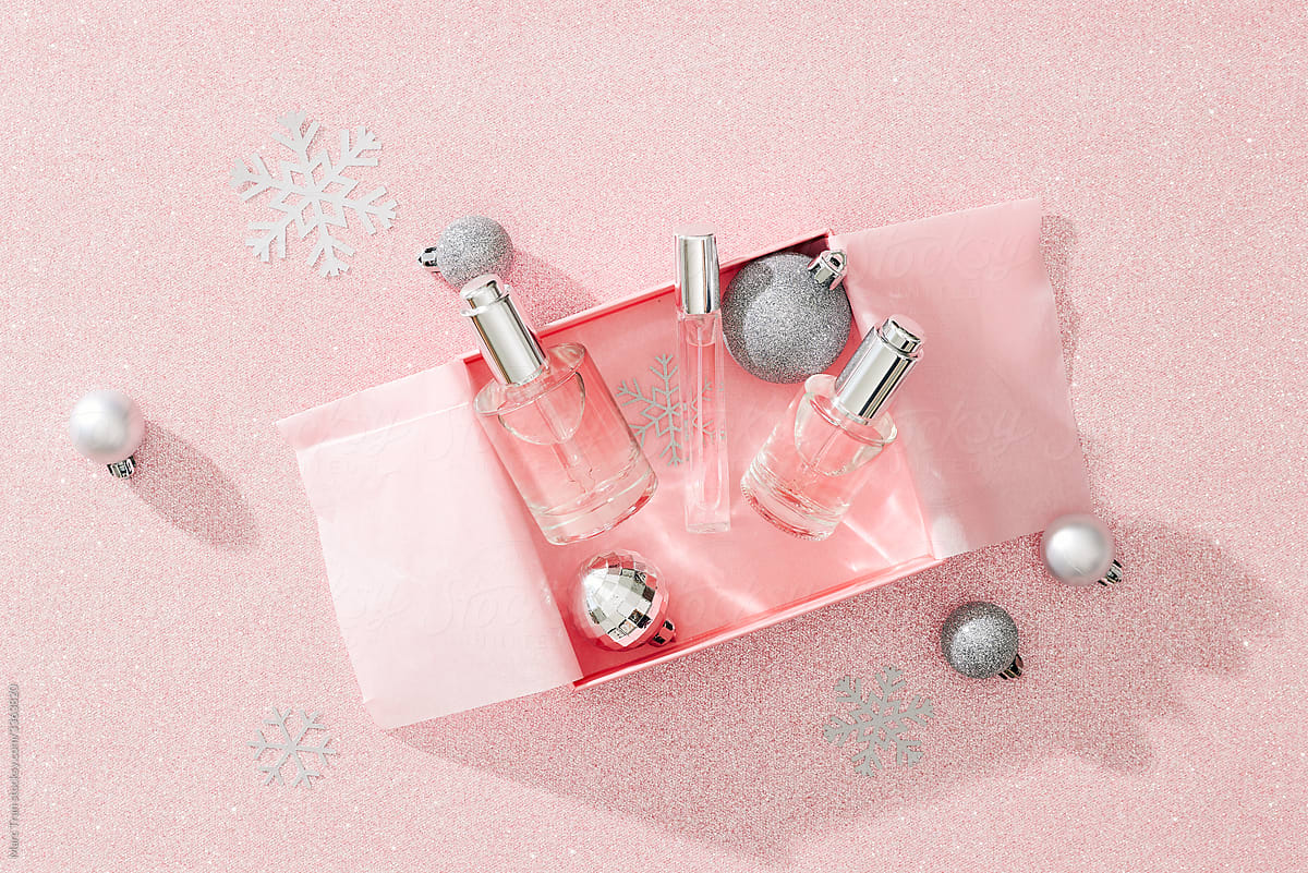 cosmetic bottles in gift box on silver confetti