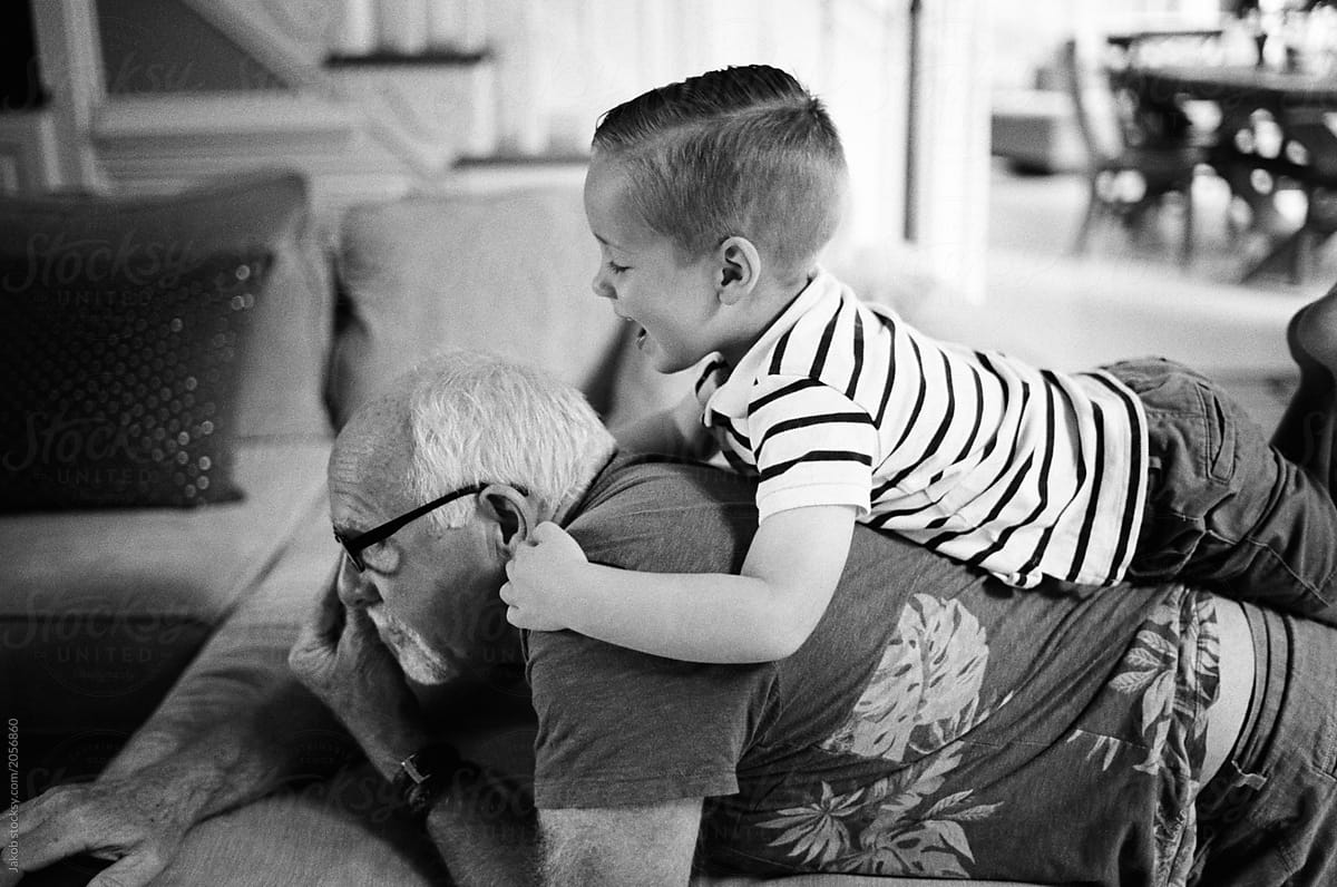 Grandson playing with grandfather on couch