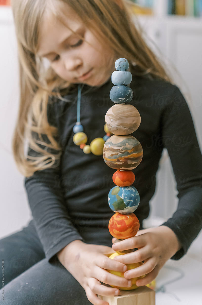 little girl plays with planet stacking toy 3