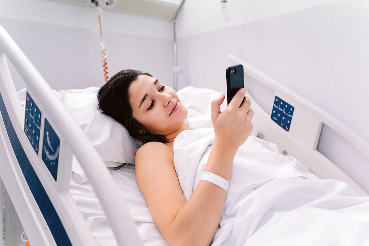 Female Patient In A Hospital Checking Her Phone.