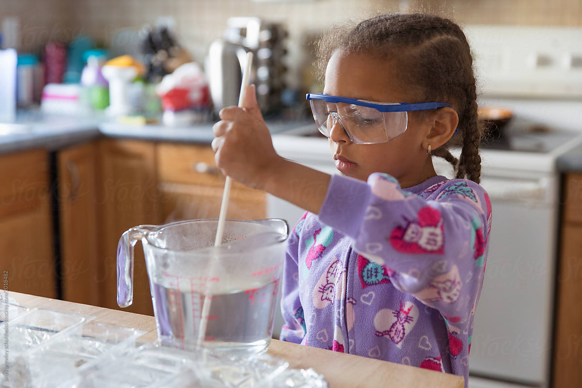 A young child mixing a solution for science.