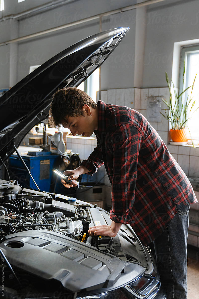 A man repairs a car in the garage