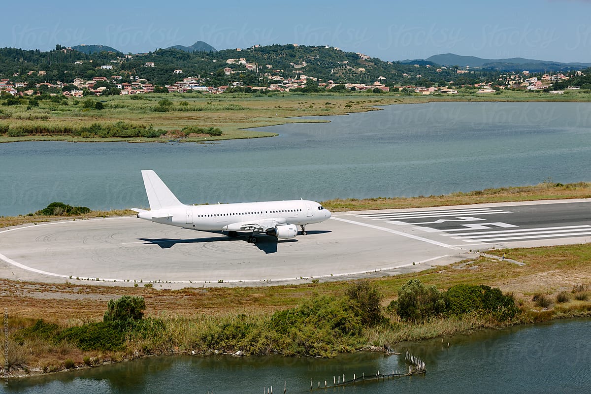 Aircraft preparing to take off from a small island runway surrounded by water