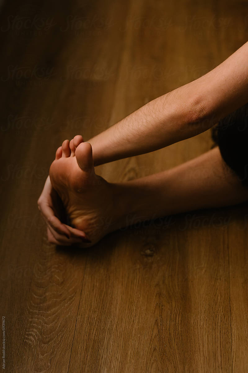Close up of the hand and foot of an individual stretching her muscles