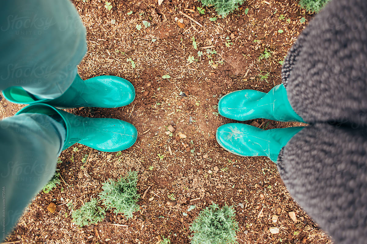 A couple standing together in green gum boots
