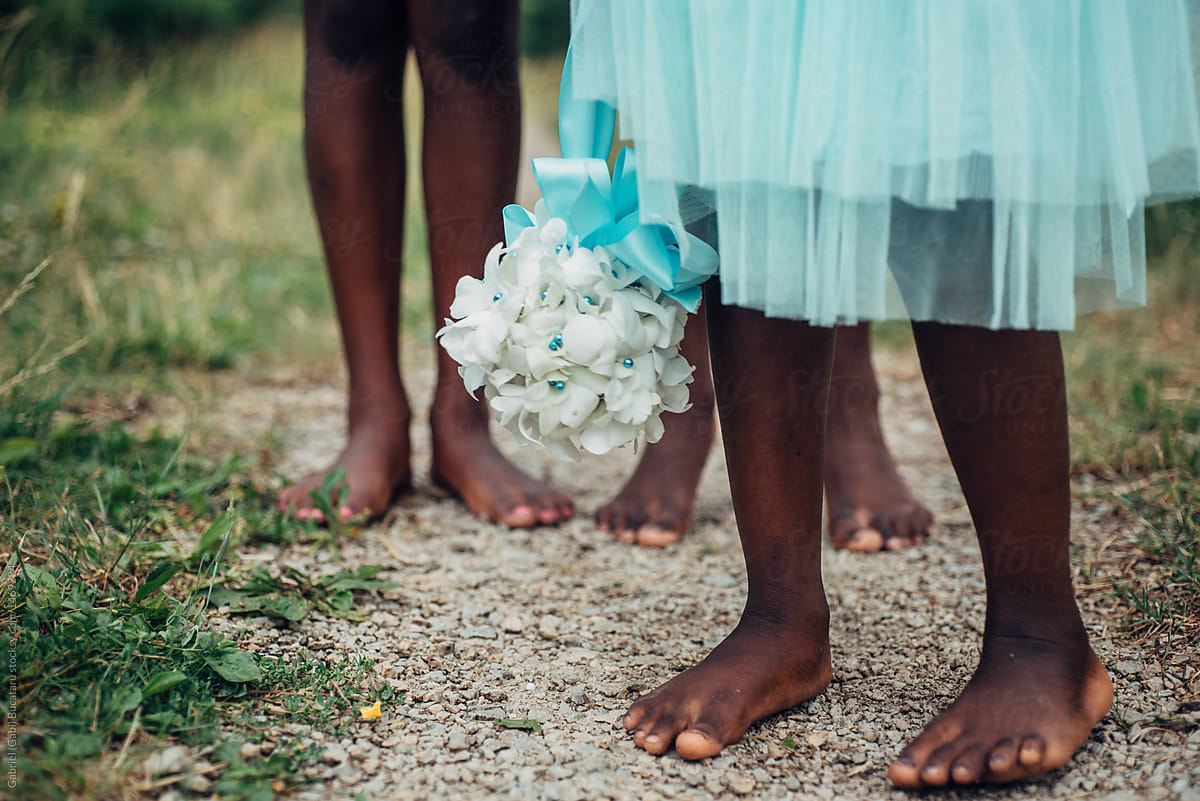 Black flower girl\'s feet on a path outdoors