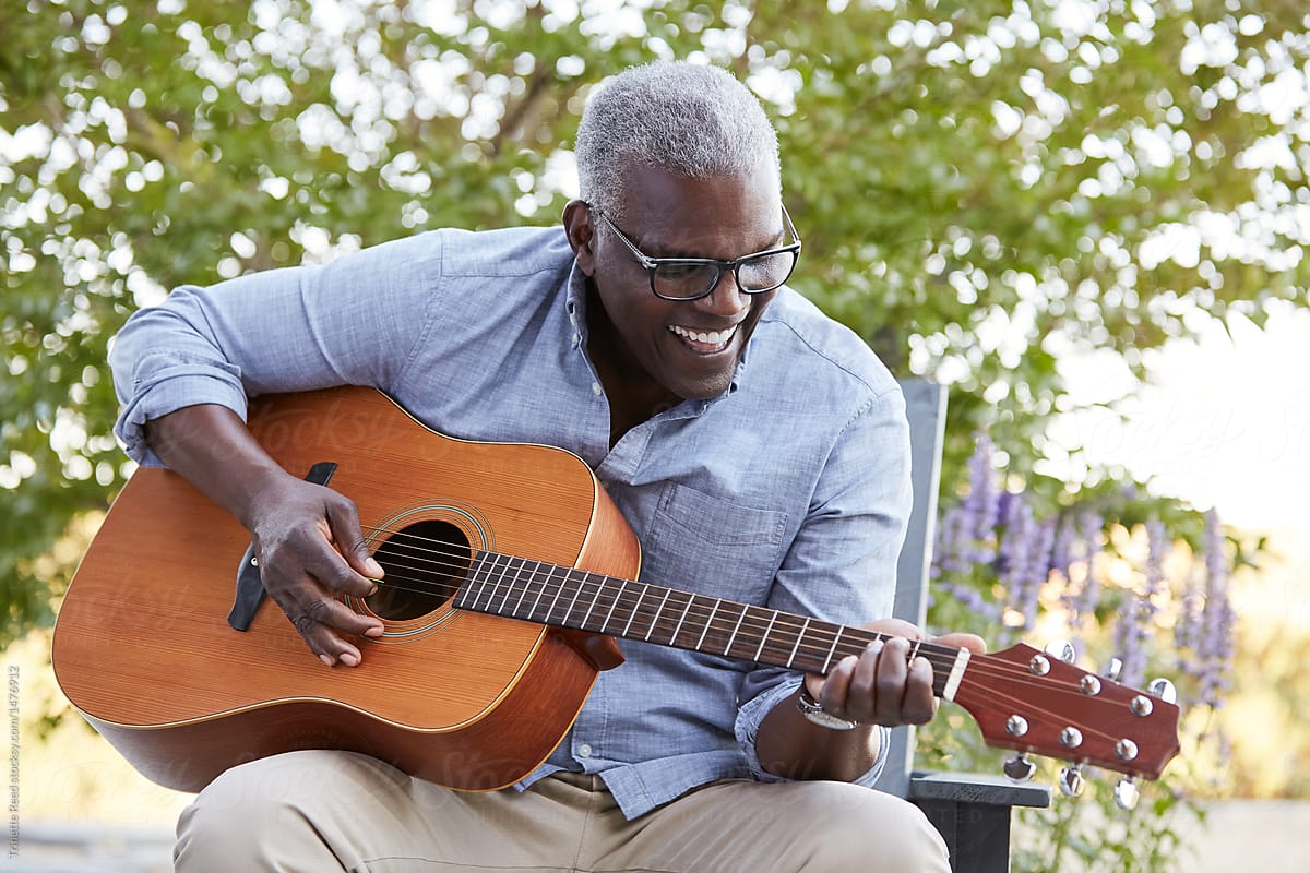 Black Senior man playing guitar