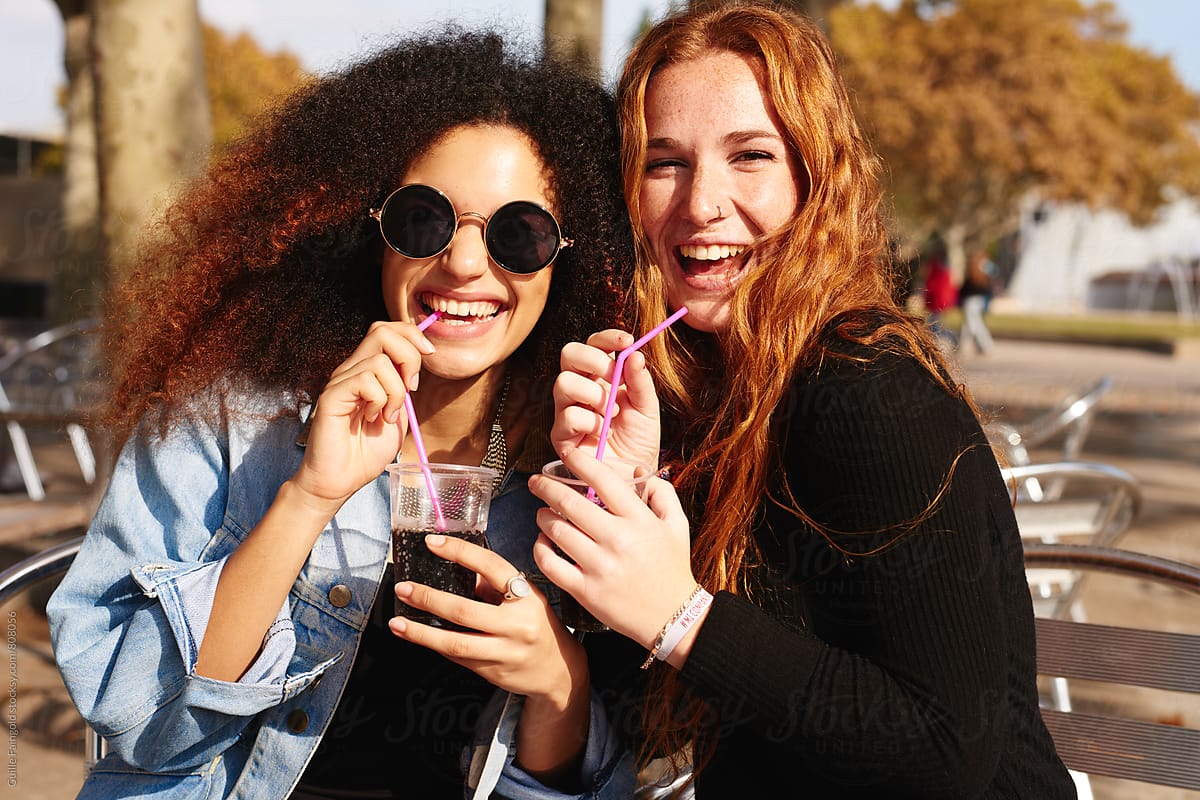 Cheerful young women with soda drinks