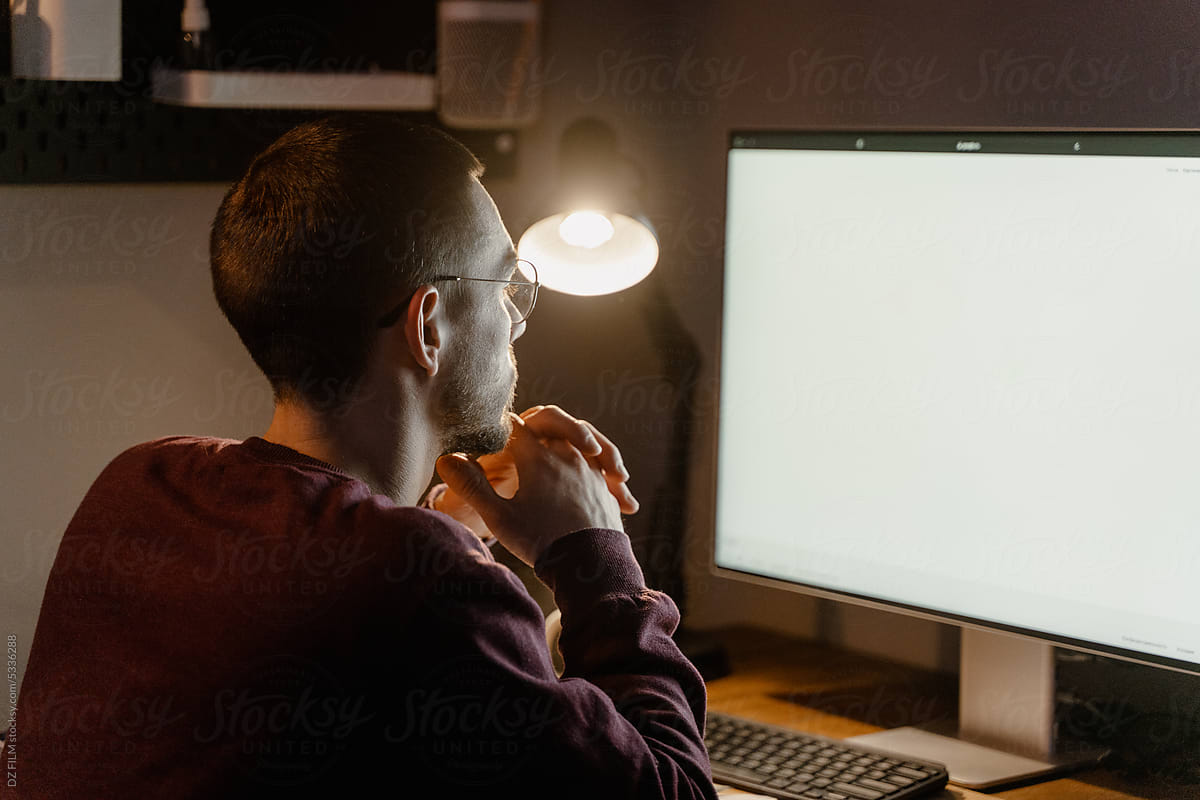 A man uses a computer while working at night