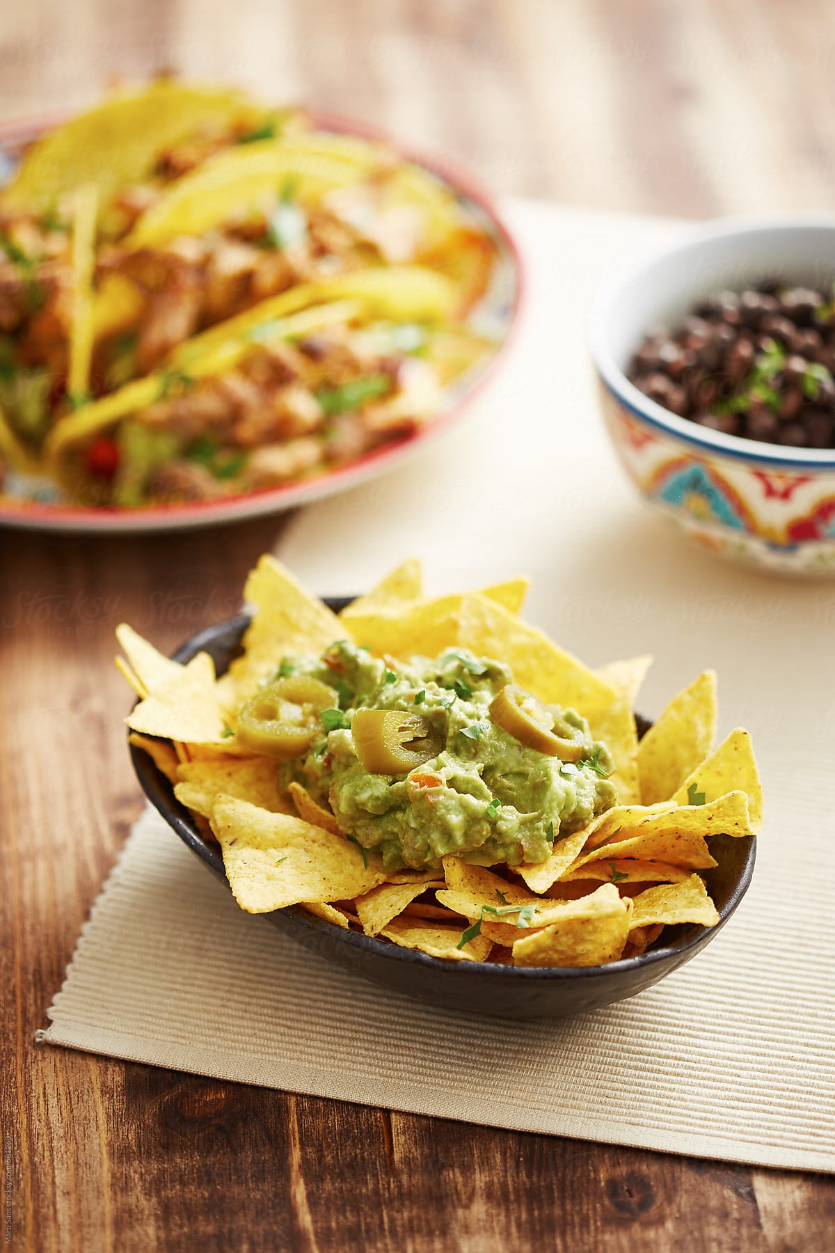 Tortilla chips with guacamole sauce, tacos, frijoles