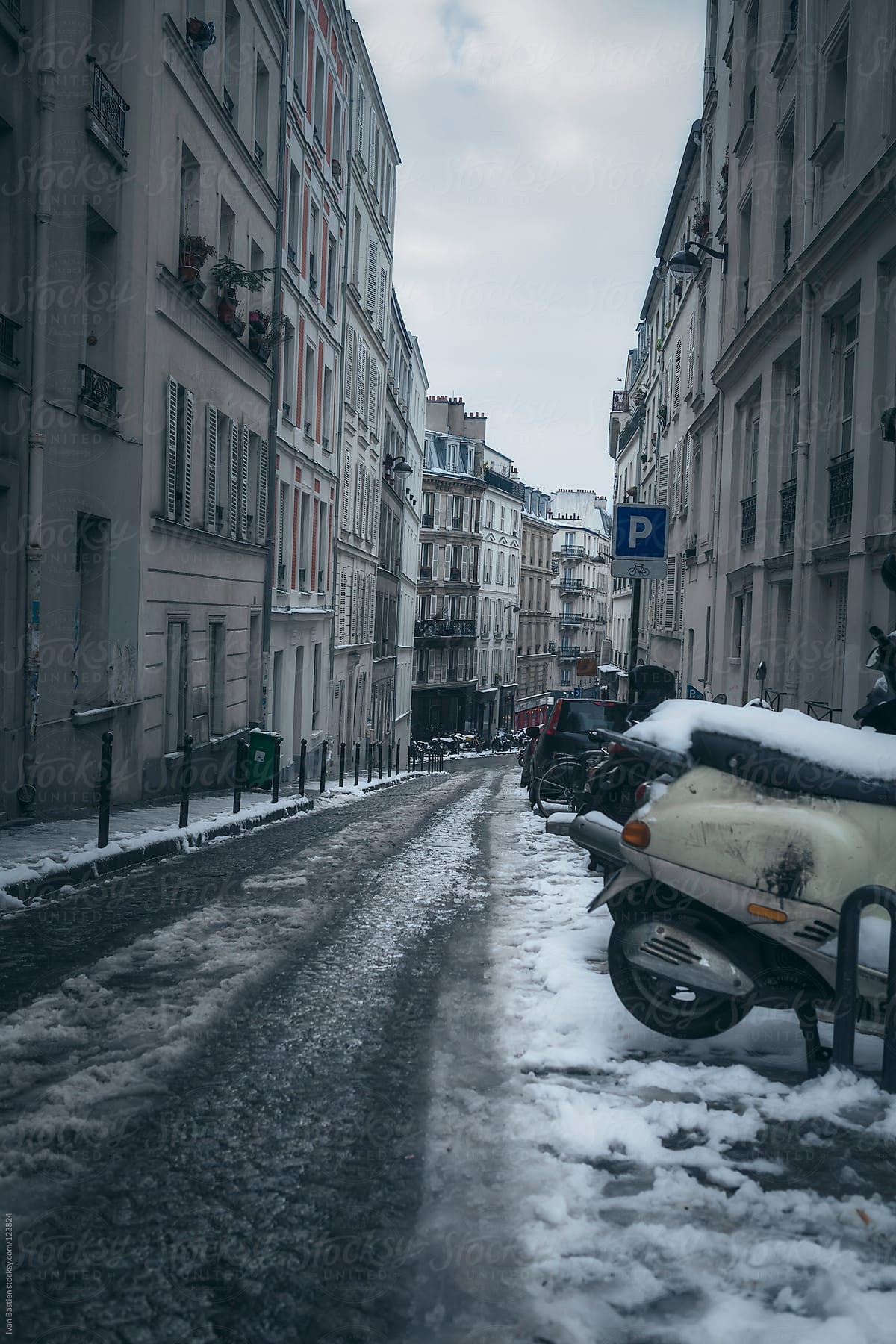 Street with snow on old pavement in Paris, France