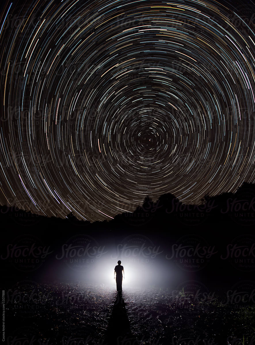 Man under night sky with star trails