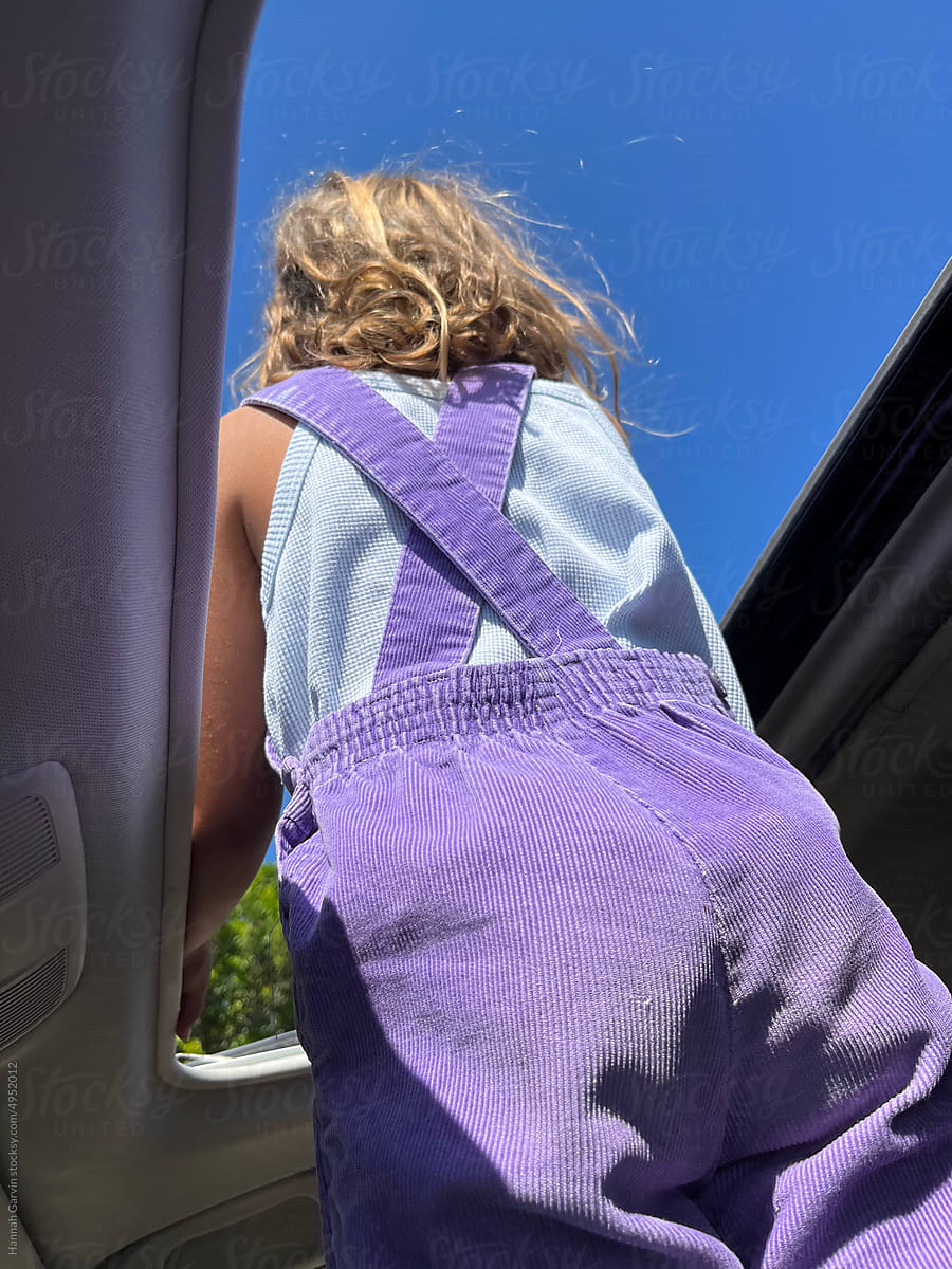 Girl looking out car sunroof