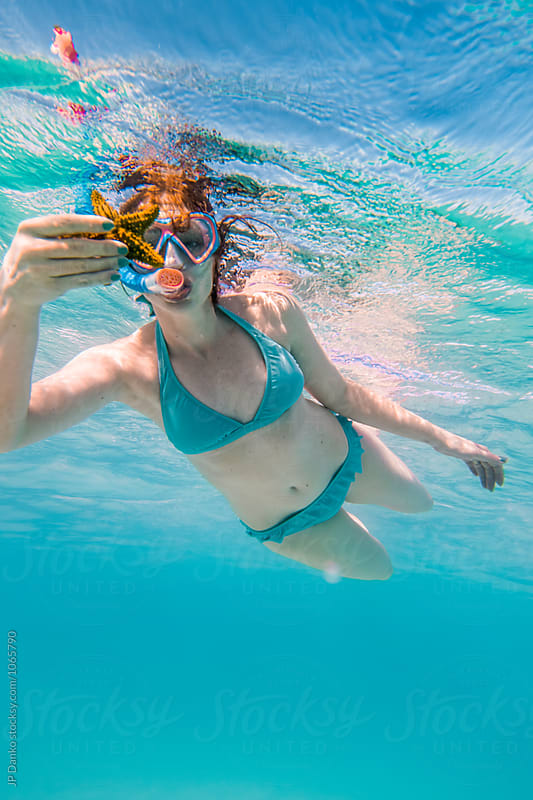 Woman In Bikini Holding Starfish Swimming Underwater at All Inclusive Caribbean Resort White Sand Beach