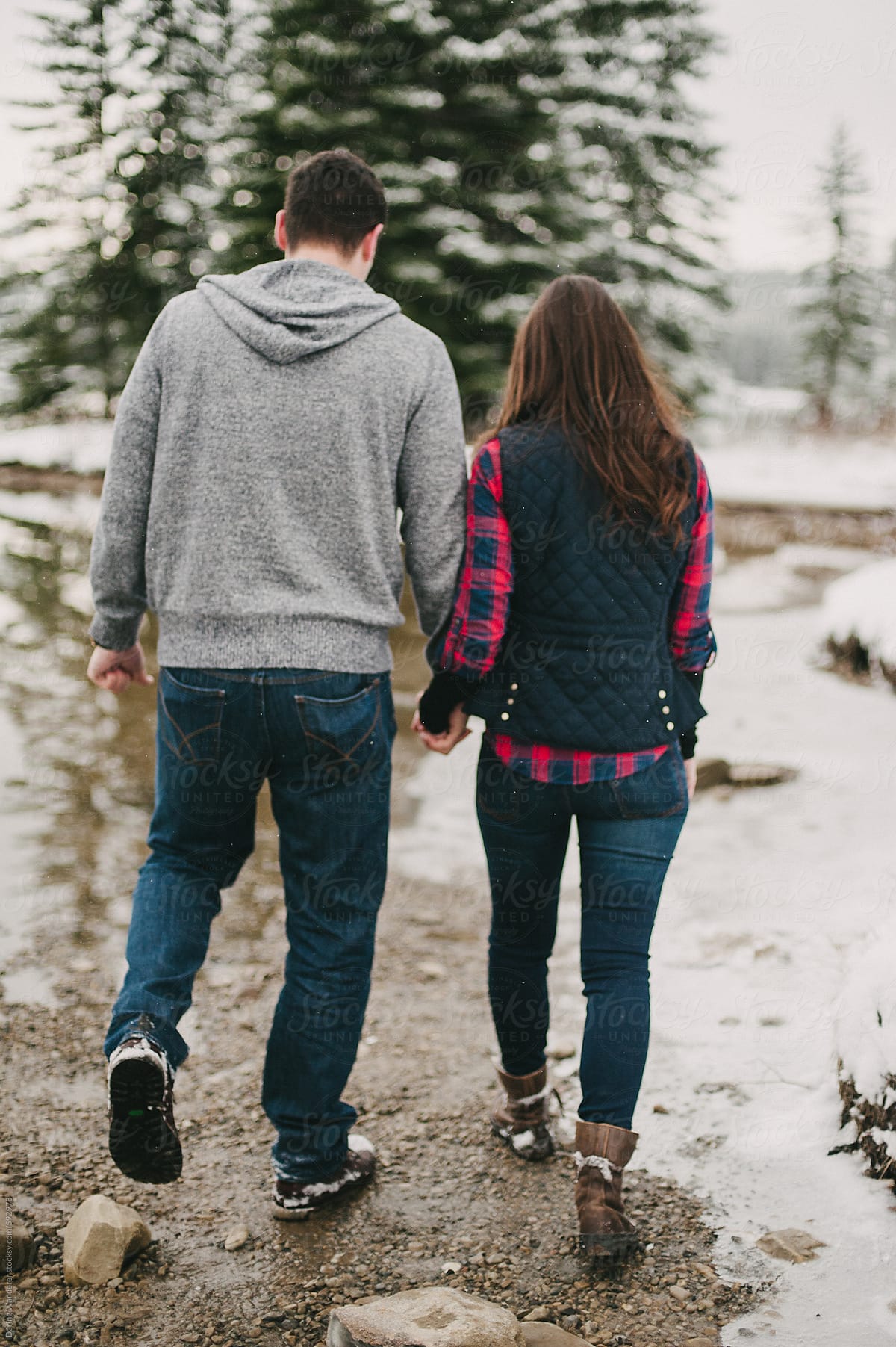 Adventurous Engaged Couple In Wintery Landscape By Stocksy