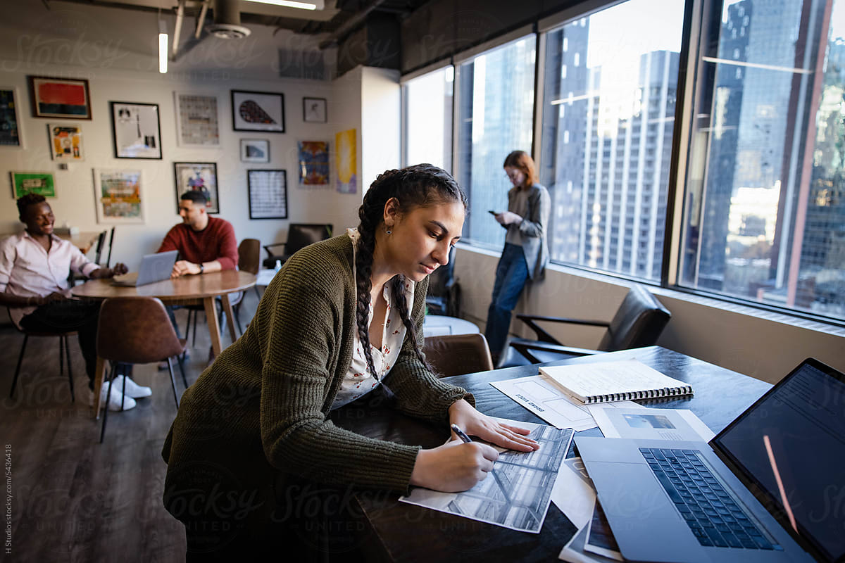 Female graphic designer editing proofs in highrise office