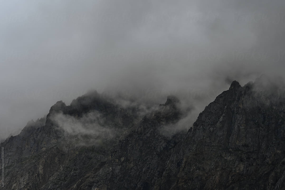 a group of mountain peaks covered with clouds