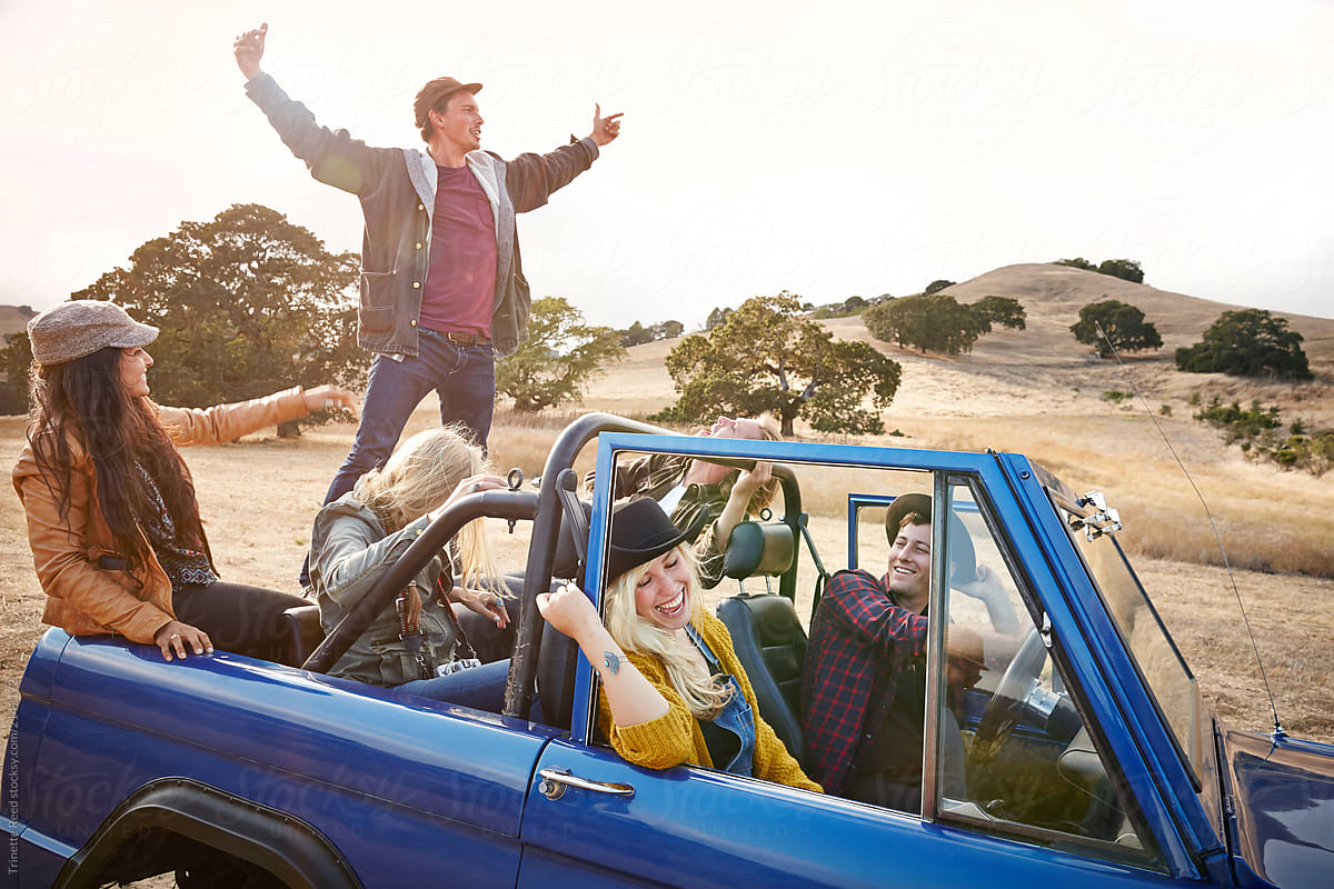 Group of friends traveling on road trip in nature having fun