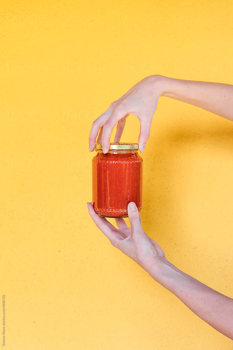 Hand holds a tomato passata sauce bottle