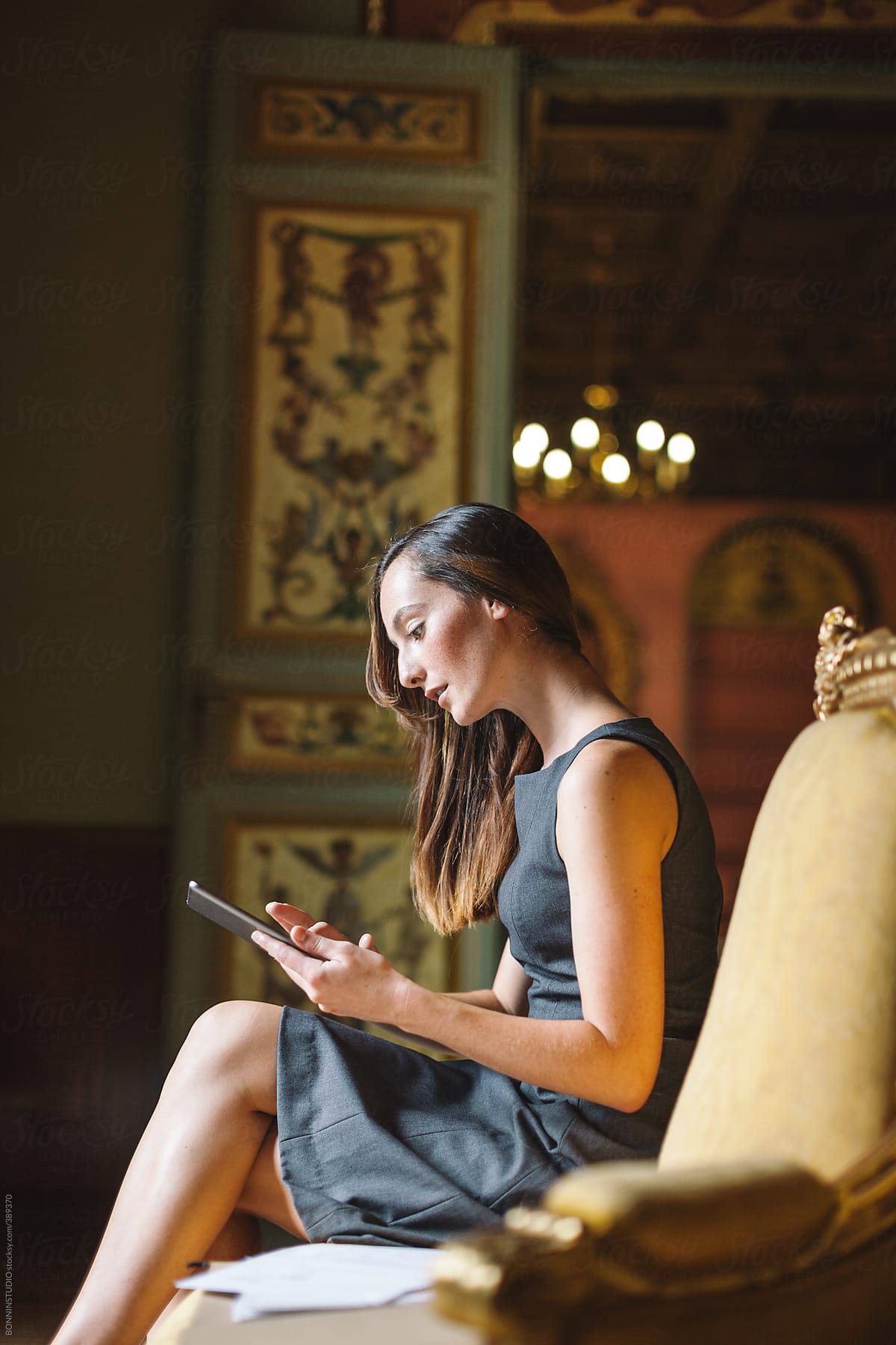 Young businesswoman working with digital tablet at beautiful baroque room.