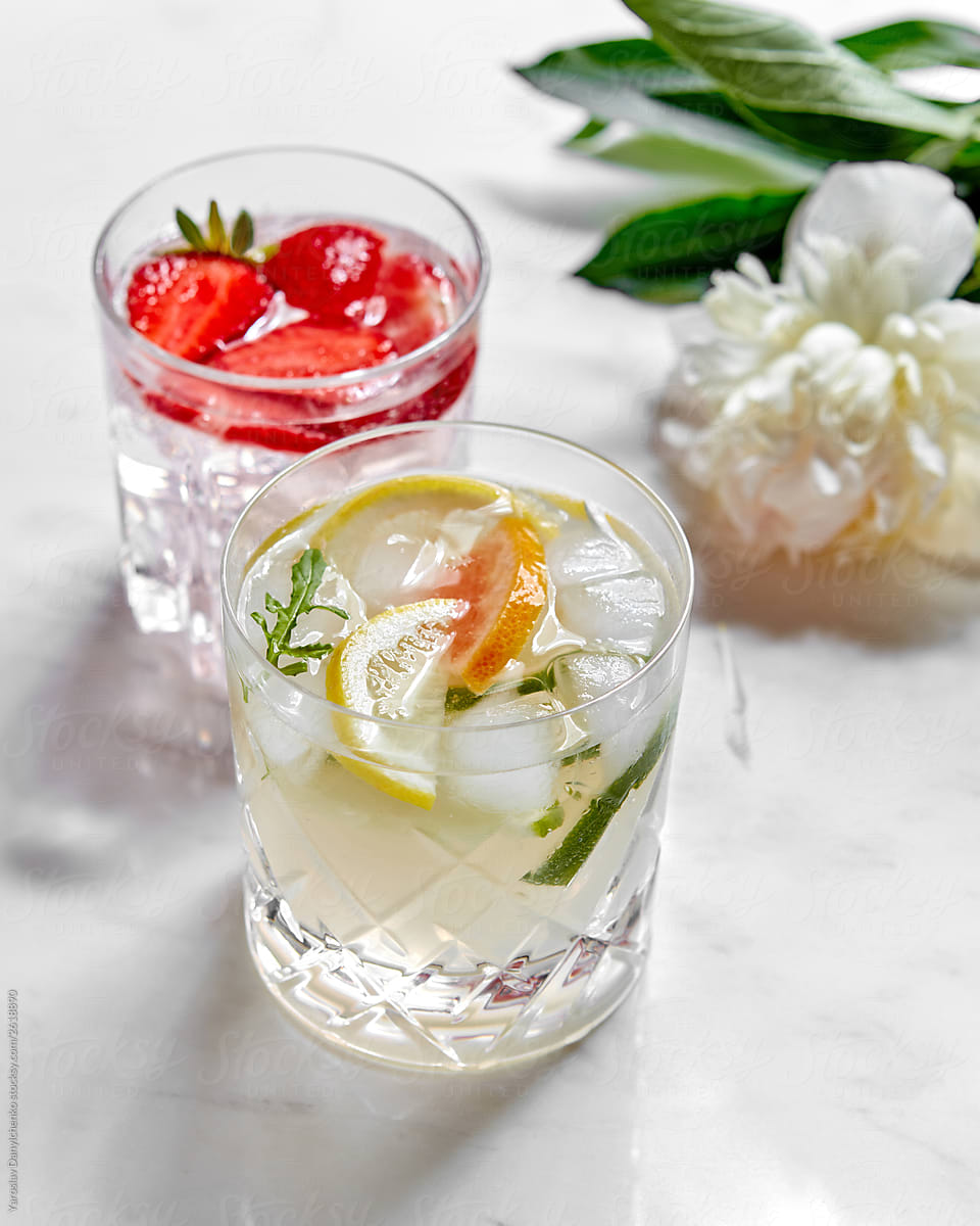Glasses with fresh drinks and flower on table