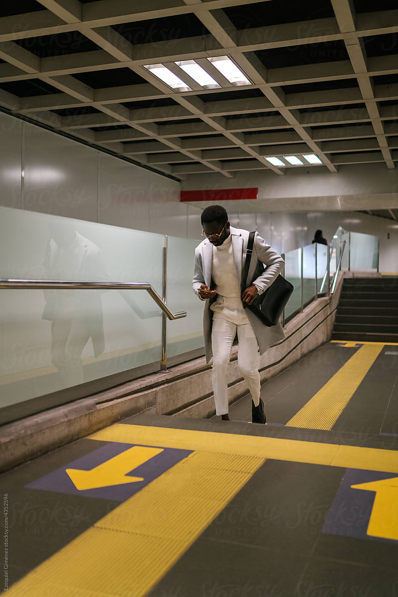 Black man using smartphone in underground passage