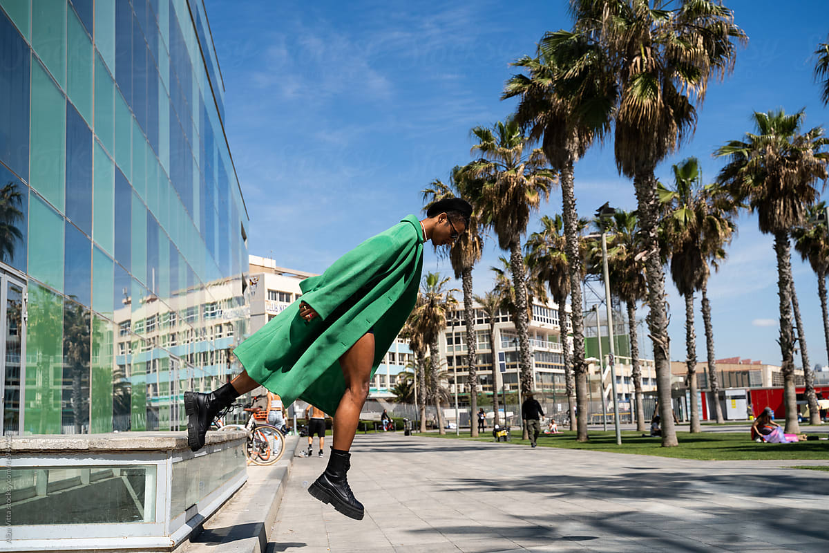 Diagonal black man levitating at city