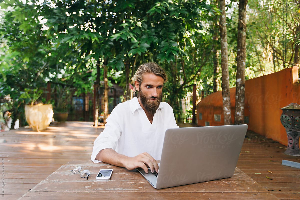 Young man working on computer in the garden