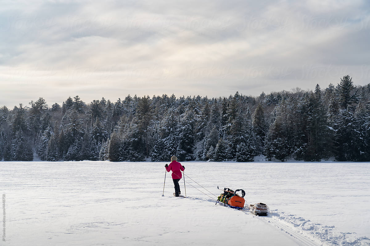 Snowshoeing with Winter Camping Gear on Frozen Lake