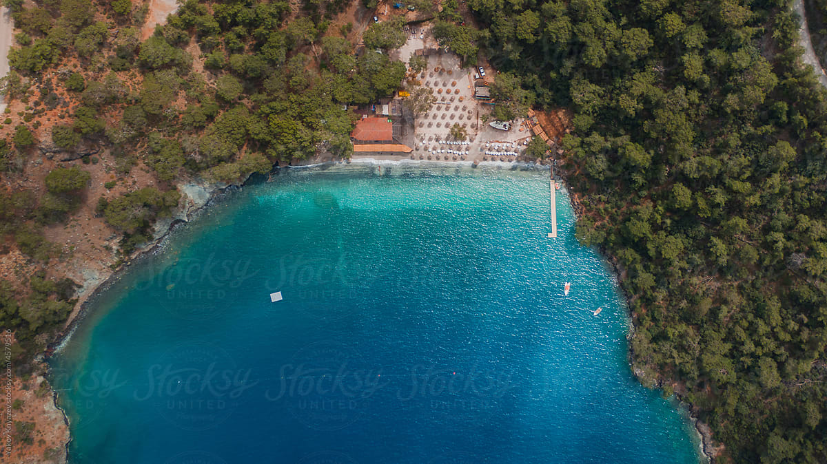 overhead aerial shot of a perfect beach in Turkey lost among woods