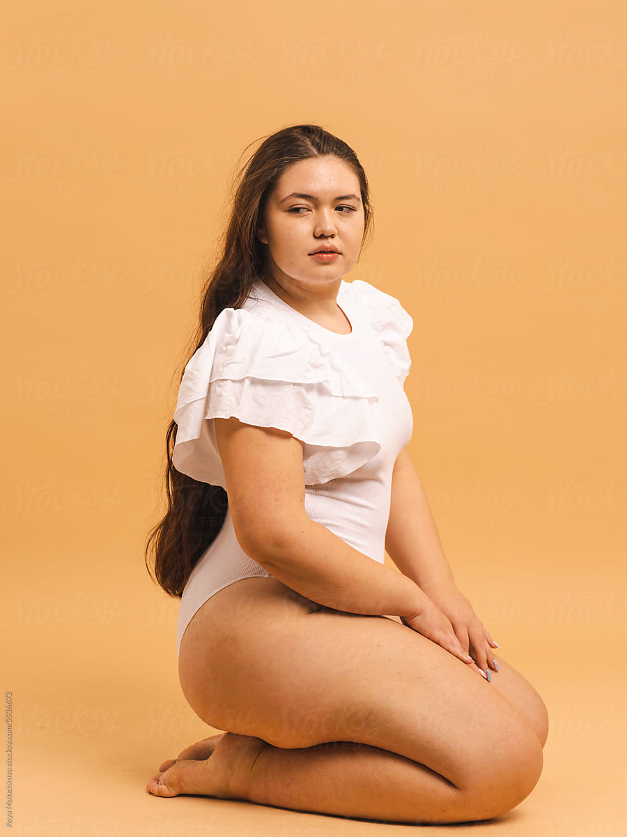 Confident Plus Size Woman in White Bodysuit